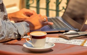 Canadian expat filing taxes online from overseas while enjoying coffee in Lisbon.